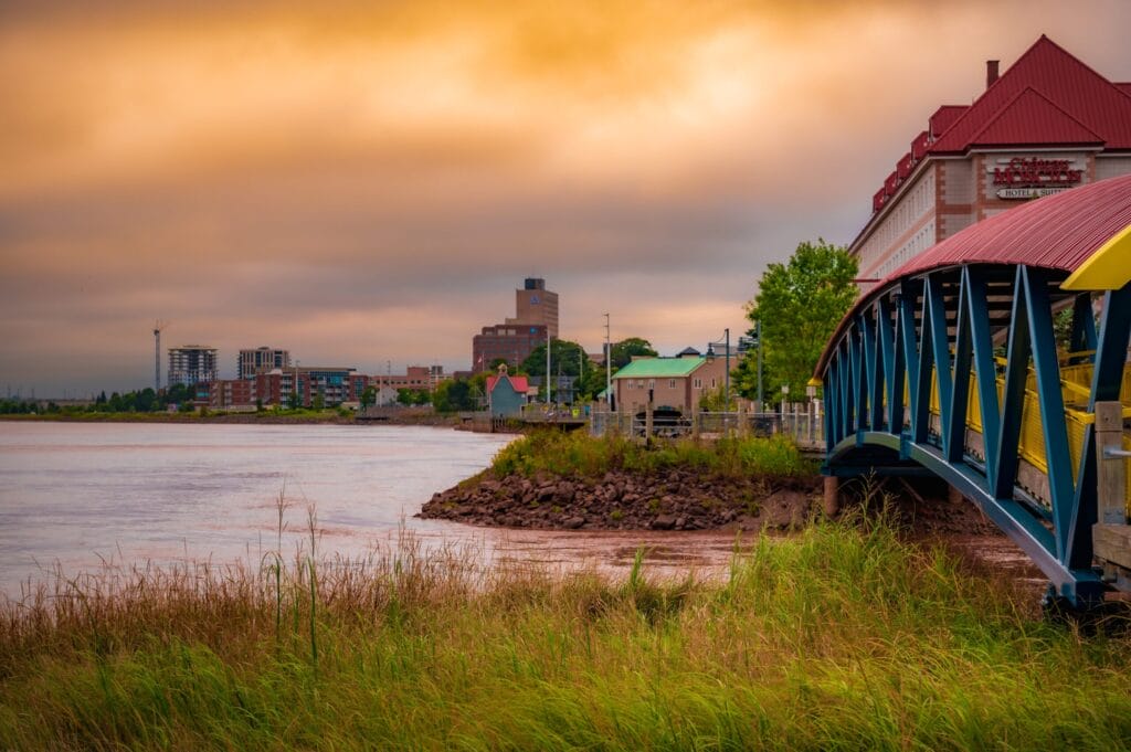 Moncton, New Brunswick, Canada - September 6 2023: city skyline, Petitcodiack River, pedestrian bridge, colourful dramatic sky.