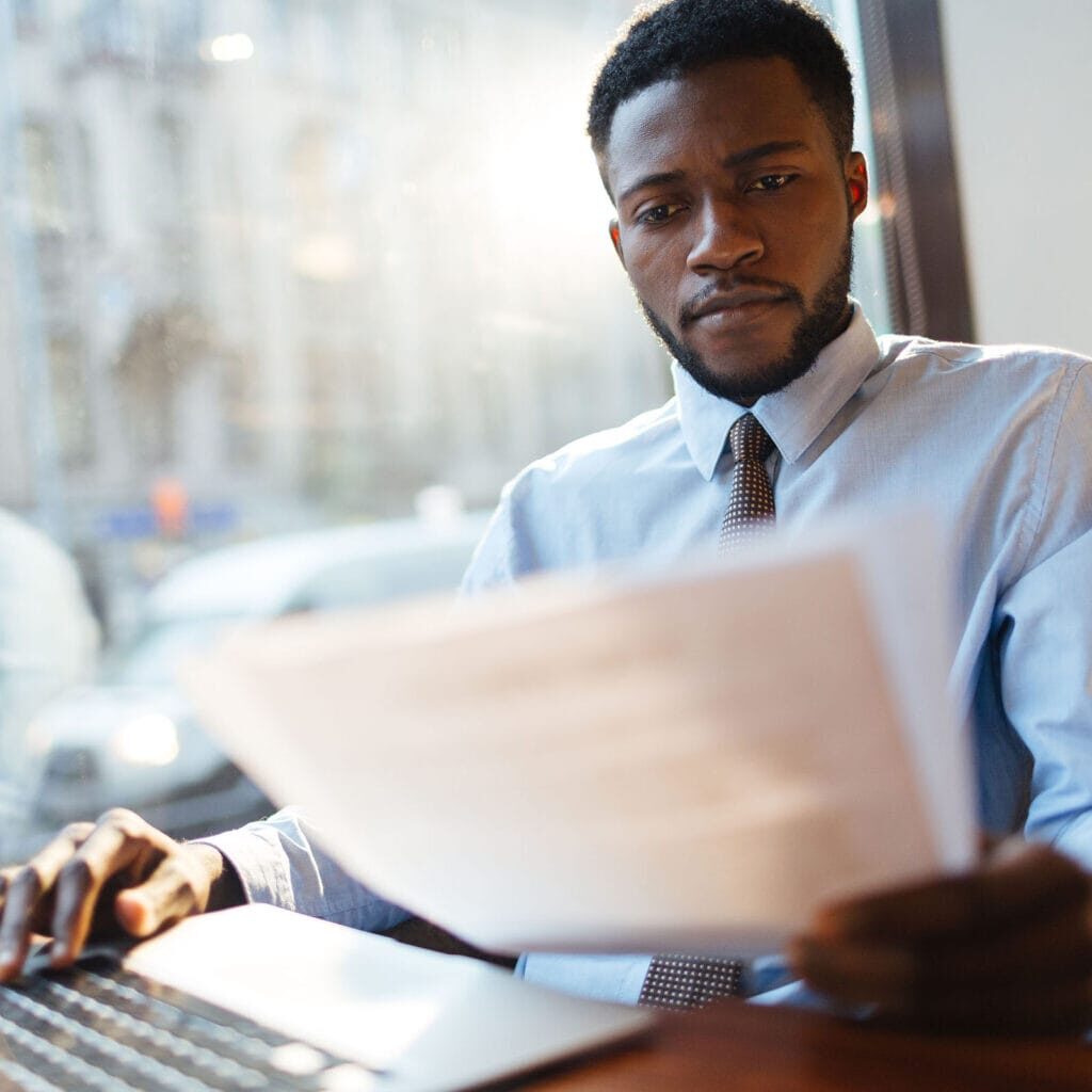 Serious employer reading resumes of candidates