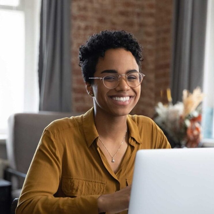 A smiling woman in front of laptop
