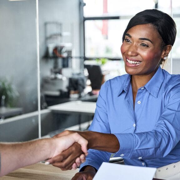 A smiling woman shaking hands with a man